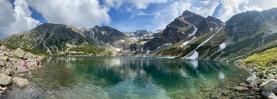 湖水在蓝天白天积雪山脉附近
